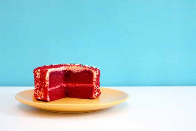 Bolo de veludo vermelho na mesa branca e fundo azul