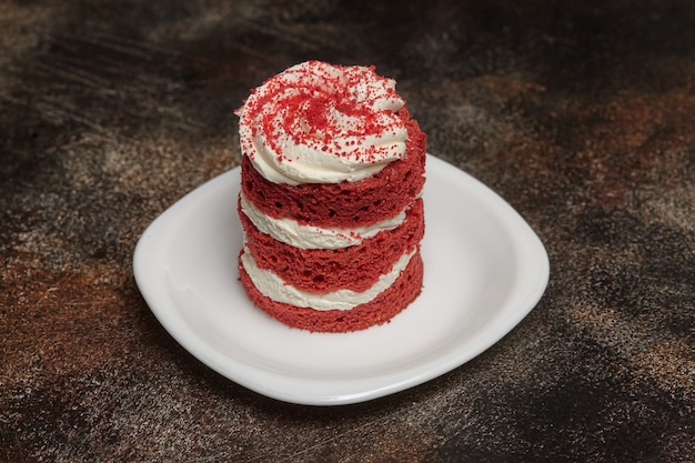 Bolo de veludo vermelho redondo com creme no prato branco