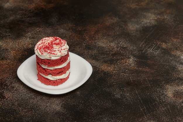 Bolo de veludo vermelho redondo com creme no prato branco