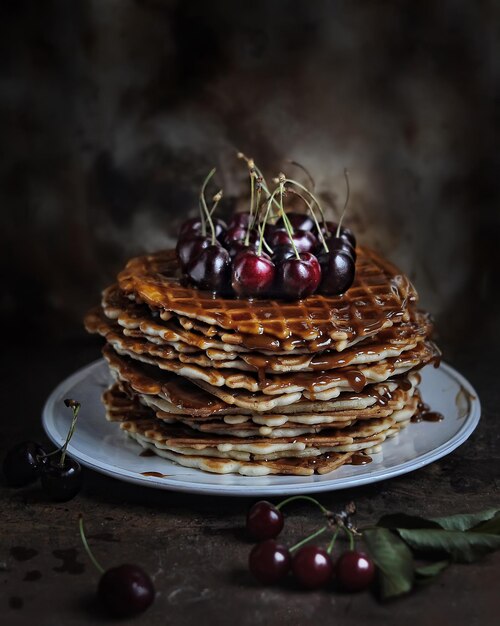 bolo de waffle decorado com cerejas em fundo desfocado escuro