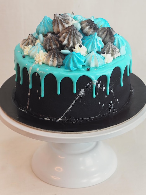 Bolo de xícara pintado de preto fosco com gotejamento azul turquesa