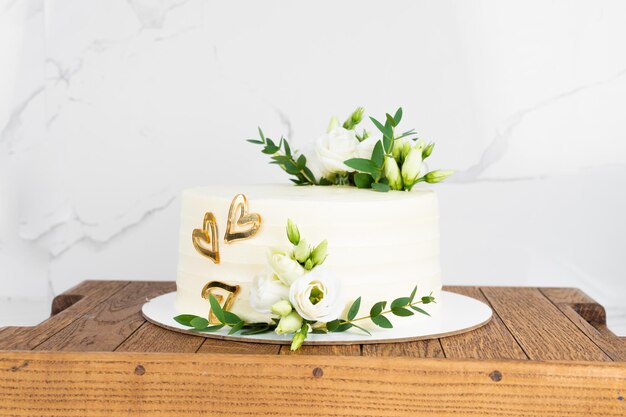 Bolo doce com decoração floral em suporte de madeira sobre parede de mármore Bolo de casamento