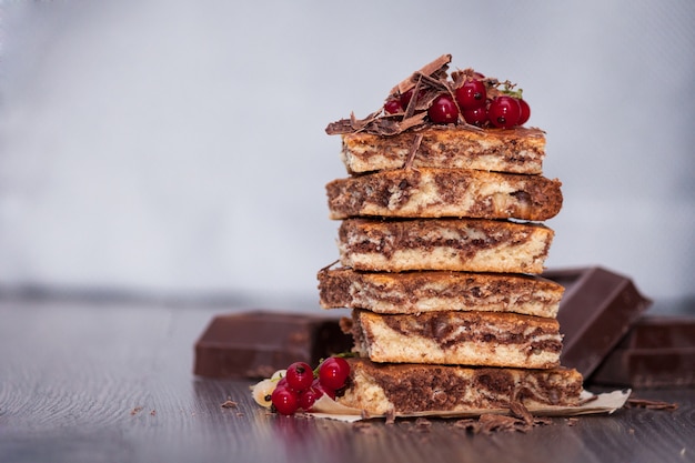 Bolo doce com zebra de cacau em pó com frutas e chocolate no fundo escuro de madeira. copie o espaço