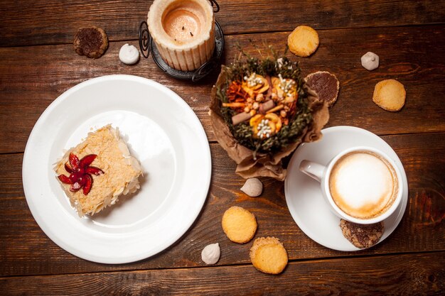 Bolo doce e cappuccino na mesa de madeira festiva