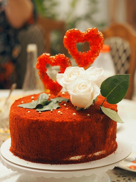 Foto bolo festivo decorado no estilo de um casamento de rubi com corações vermelhos e rosas delicadas