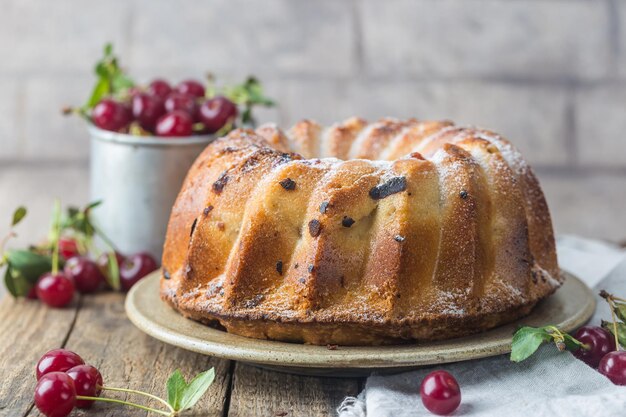 Bolo fresco caseiro com cereja na mesa de madeira