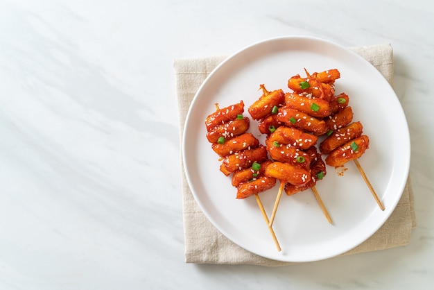 Bolo frito de arroz coreano (tteokbokki) espetado com molho picante