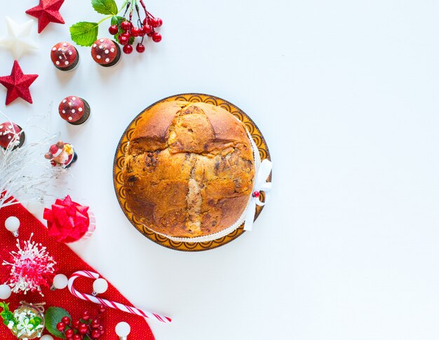 Bolo italiano do natal do panetone do chocolate com os cones do candlepine das decorações do bauble em um fundo de madeira.