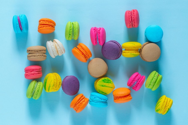 Bolo macaron ou macaroon em fundo turquesa de cima de cores pastel de biscoitos de amêndoa coloridos