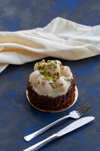 Bolo profiterole de chocolate branco em um fundo preto e azul