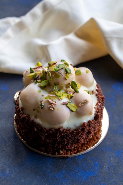 Bolo profiterole de chocolate branco em um fundo preto e azul