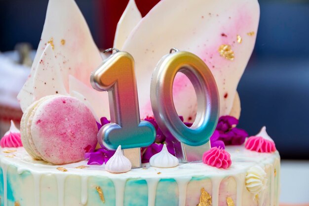Foto bolo rosa branco e azul com o número 10 em cima da mesa no contexto de pacotes com presentes aniversário feriado infantil