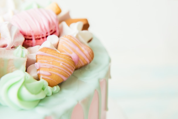 Bolo rosa com corações, macarons e marshmallows. foco seletivo