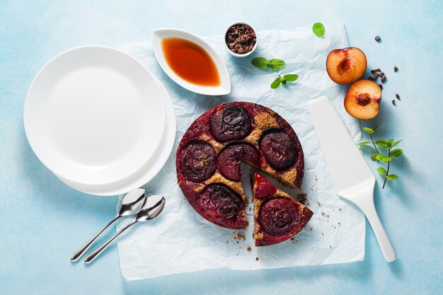 Bolo vegano com ameixas frescas e xarope de bordo.