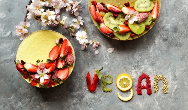 Bolo vegano cru com frutas e sementes, decorado com flores