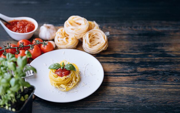 Boloñesa de pasta italiana con parmesano rallado y albahaca ingredientes de primer plano en el fondo