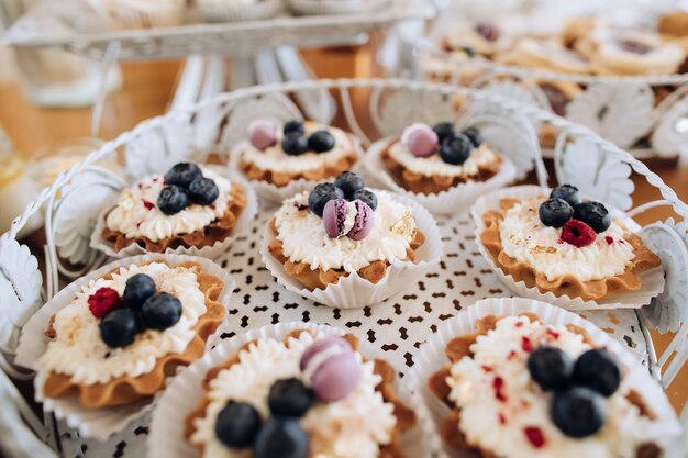 Bolos com creme e mirtilos em uma festa de casamento Mesa com doces