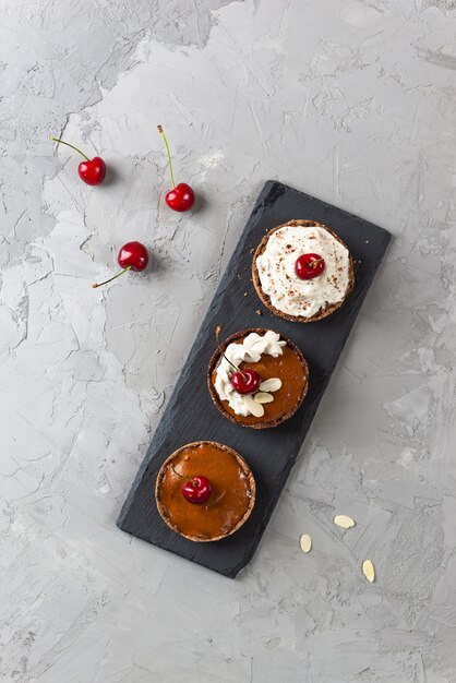 Bolos crus com creme de coco, cerejas, amêndoas e banana