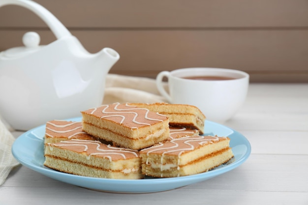 Bolos de esponja saborosos e bebida quente enquanto mesa de madeira