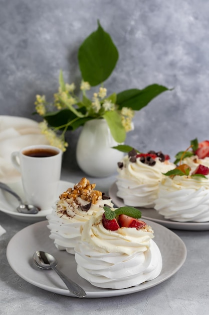 Bolos de merengue Pavlova com chantilly e morangos frescos folhas de hortelã Foco seletivo