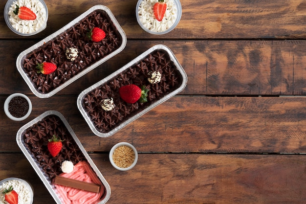 Foto bolos de morango com chocolate em uma mesa de madeira. espaço para texto.