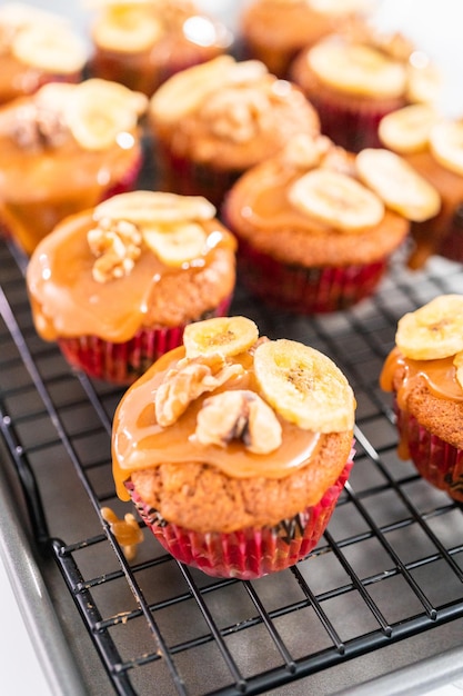 Bolos de pão de banana recém-assados regados com caramelo caseiro, decorados com nozes e chips de banana.