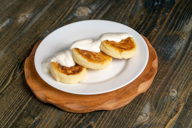 Bolos de queijo cottage são comidos com creme de leite ou geléia