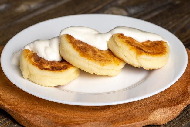 Bolos de queijo cottage são comidos com creme de leite ou geléia