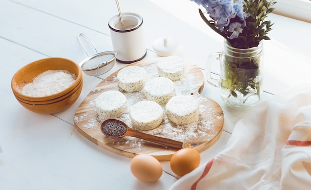 Bolos de queijo cru com sementes de papoila numa superfície de madeira