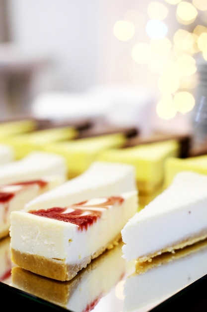 Bolos de queijo em uma bandeja de espelho sobre uma mesa de bufê contra o fundo de bokeh dourado