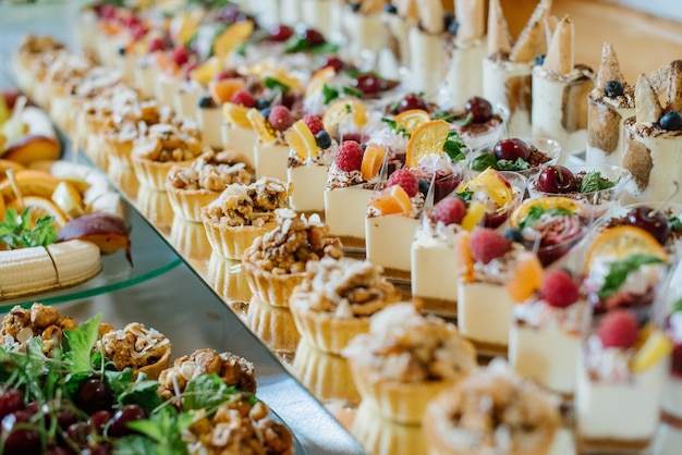 Bolos de sobremesa doce e cupcakes e geleias na barra de chocolate na celebração