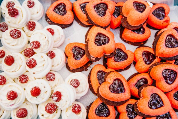 Bolos deliciosos em forma de coração em uma mesa para convidados doces coloridos para ocasiões especiais em uma bandeja closeup