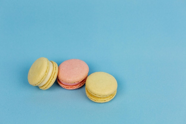 Bolos multicoloridos em um fundo azul macaroons de laranja doces