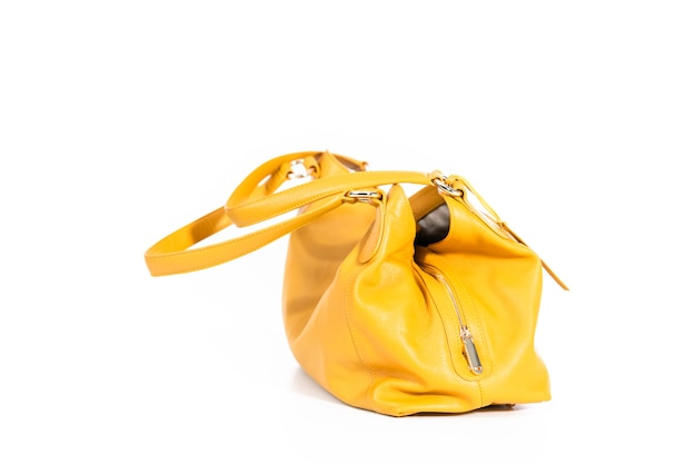 Bolsa amarela das mulheres em um fundo branco.
