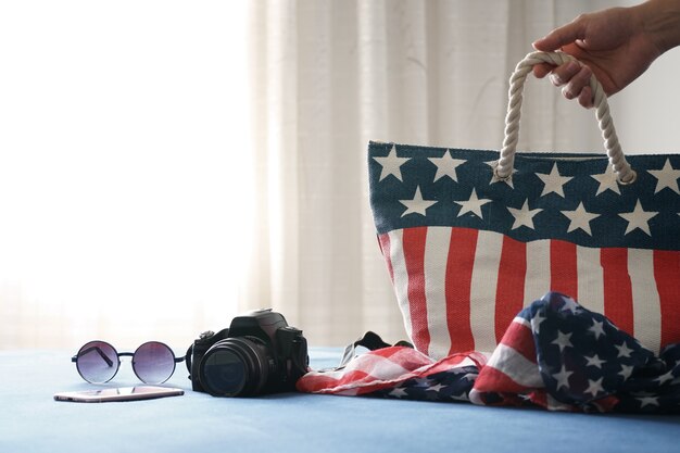 Bolsa americana no hotel em nova york com câmera de acessórios de viagem, óculos de sol