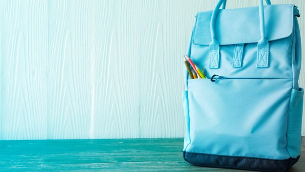 Foto bolsa azul claro con lápices adentro lista para volver a scholl