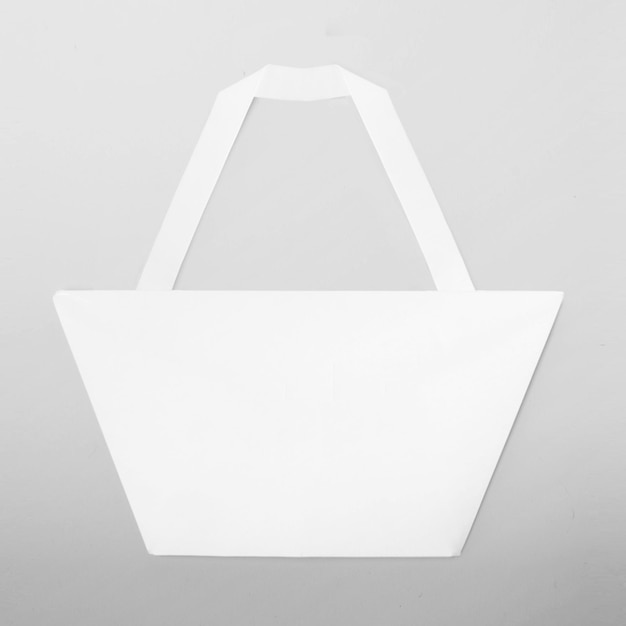 Foto bolsa en blanco de compras de origami blanco en un gris