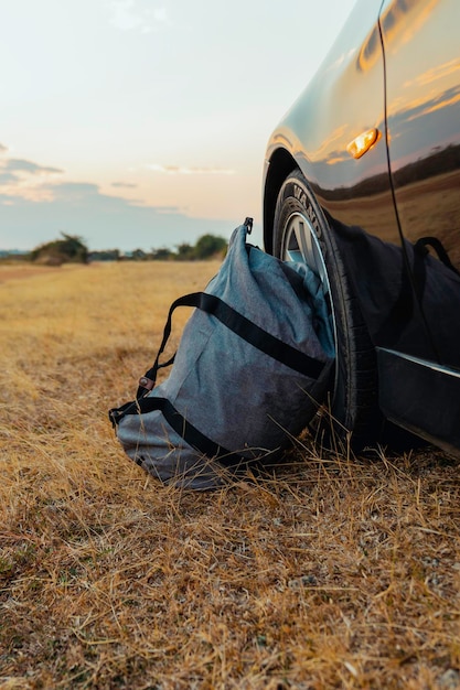 Bolsa cinza ao lado da roda do carro na estrada Foto Premium