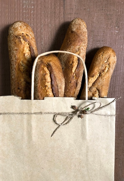 Bolsa de compras con pan en el fondo de madera, concepto de entrega en línea.