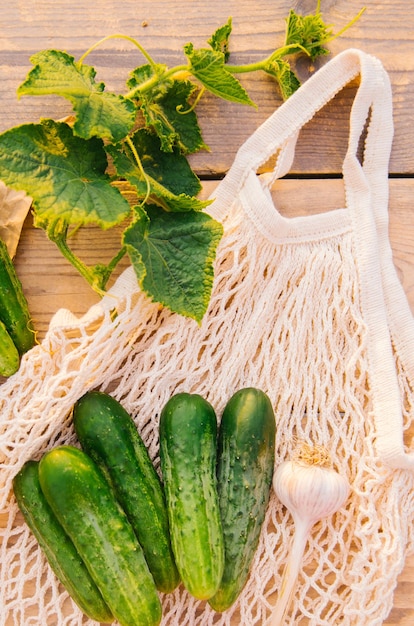 Bolsa de compras reutilizable hecha de materiales reciclados en una mesa de madera entre verduras frescas Sin plástico Estilo de vida ecológico