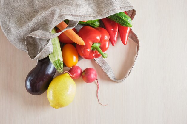 Bolsa de compras tejida con cadena de malla reutilizable ecológica con frutas y verduras en la mesa, concepto de desperdicio cero