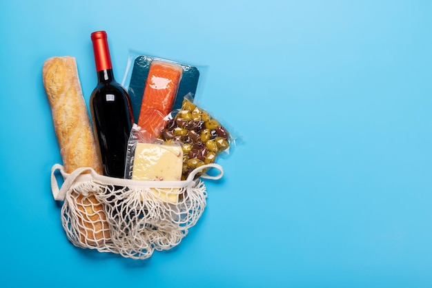 Bolsa de compras con vino y comida.