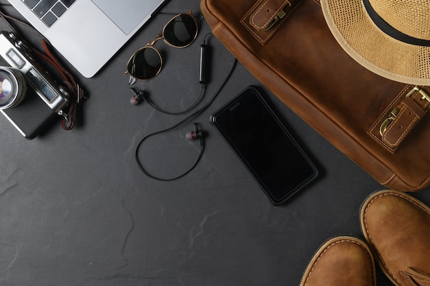 Bolsa de couro com o smartphone no fundo de pedra preto.