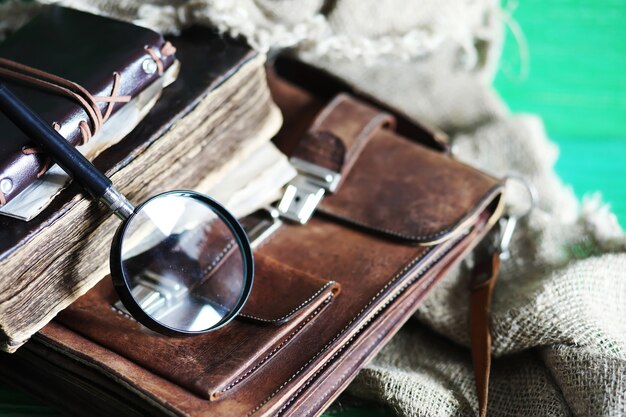 Bolsa de couro velha com uma lupa sobre um fundo de mesa de madeira marrom de viajante com espaço de cópia.