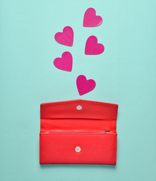 Bolsa de couro vermelha com corações decorativas em um fundo azul pastel, conceito de amor, minimalismo