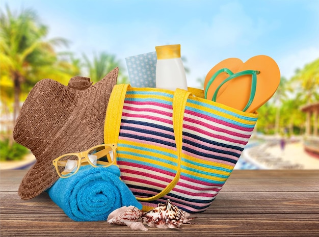 Bolsa de praia com acessórios de verão na luz de fundo