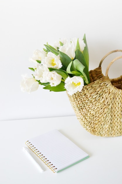 Bolsa de vime com flores tulipa e caderno