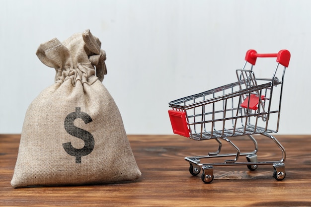 Bolsa de dinero junto a un carrito de la tienda