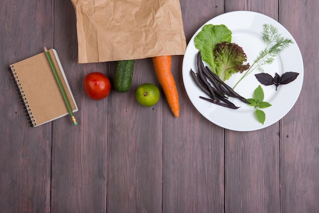 Bolsa ecológica de papel de concepto de comida vegetariana saludable con varios platos de verduras saludables