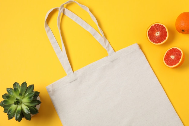 Bolsa ecológica, planta suculenta y naranja sobre fondo de color